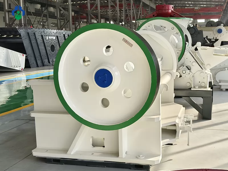PE jaw crusher side view at manufacturing plant showing flywheel and V-belt drive